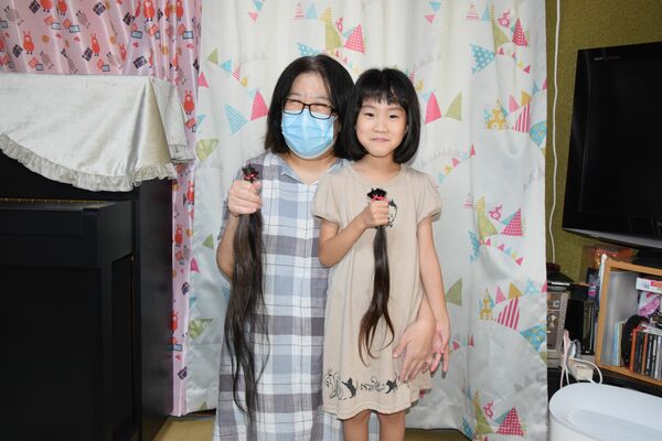 提供する髪を手にする沙耶さん（右）と英理子さん