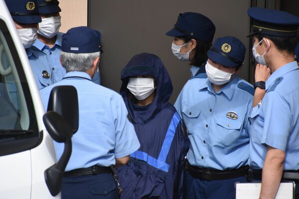 送検される伊藤容疑者（中央）＝14日午前、鹿沼署