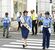 金メダルを胸に手を上げて横断歩道を渡る鏡選手（中央）＝21日午前、宇都宮市インターパーク４丁目