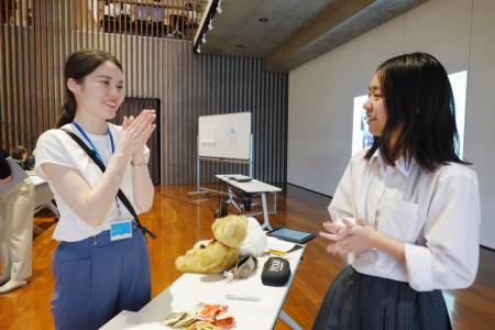 　催しで高校生と談笑する松井千枝さん（左）＝新潟県十日町市