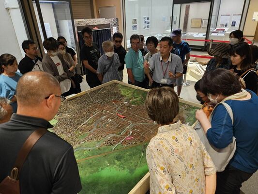 解説員の話に耳を傾ける来場者＝30日午後、県立博物館