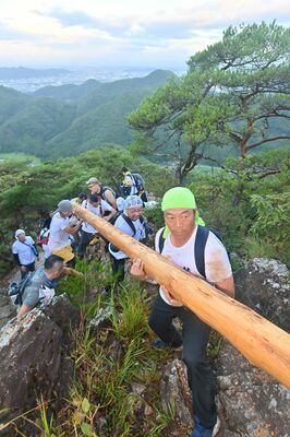 梵天祭りで巨大な丸太を運ぶ担ぎ手たち＝昨年８月１４日