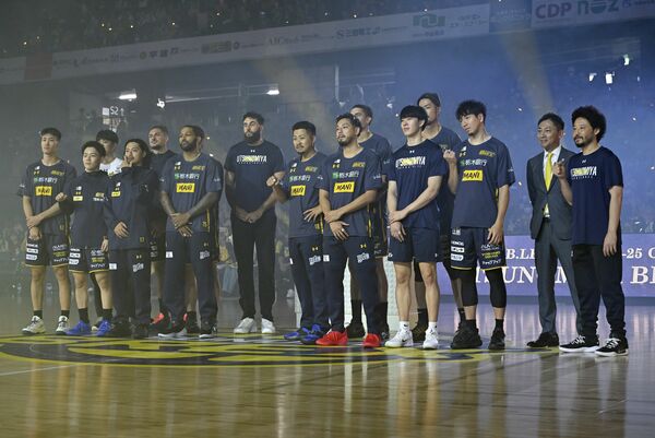 試合前に行われたチャンピオンリング贈呈セレモニーで、記念撮影に応じるブレックスの選手とBリーグチェアマンの島田氏(右から2人目)=日環アリーナ栃木、森田大地撮影