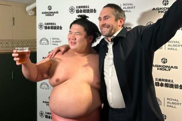 　館内の従業員（右）から振る舞われたビールを手に記念撮影する宇良＝ロンドン（共同）