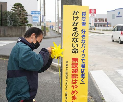 事故現場に黄色い風車を設置する楠野さん