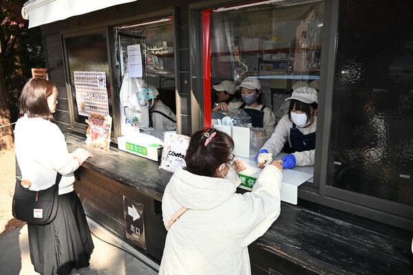 モンブランアイスデニッシュを客に手渡す生徒