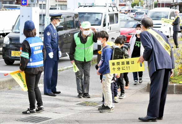 警察官や地域住民らに見守られながら登校する児童たち＝18日午前７時45分、鹿沼市樅山町