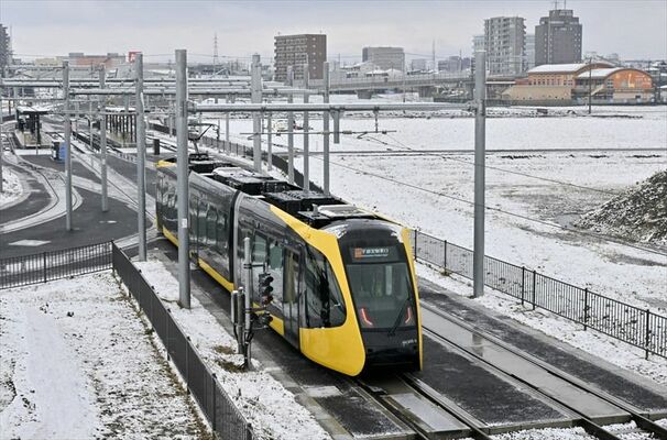 雪景色の中、運行するライトライン＝８日午前８時55分、宇都宮市下平出町
