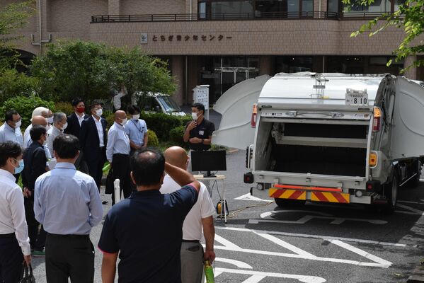 ごみ収集車の安全装置を見学する講習会参加者ら＝６日午前、宇都宮市駒生１丁目
