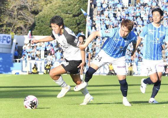 後半７分、右サイドを突破する栃木ＳＣのＦＷ小堀（左）＝横浜市のニッパツ三ツ沢球技場、田井伎撮影