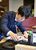揮毫する藤井棋王＝16日午後４時25分、日光きぬ川スパホテル三日月