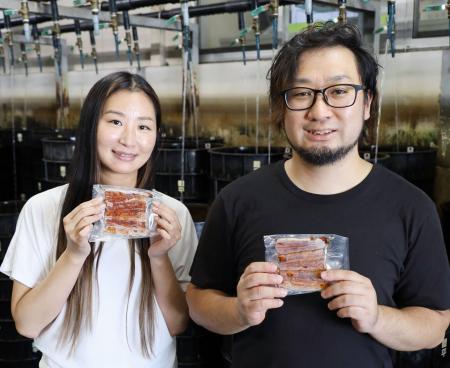 　アルコールフリーのたれを使ったウナギのかば焼きを手にする鯉平の営業事務課長松井洋一さん（右）ら＝８月、さいたま市