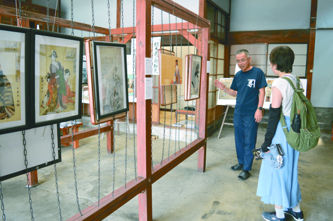 来館者に作品の解説をする阿部治館長