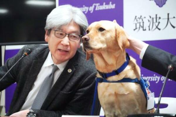 ファシリティドッグとして訓練中の「ミコ」と記者会見する平松祐司筑波大病院長=29日、茨城県つくば市