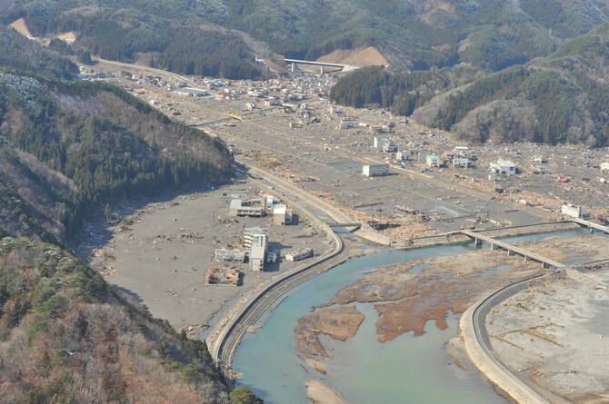 津波で甚大な被害を受けた岩手県釜石市鵜住居地区。中央左側に鵜住居小と釜石東中の校舎が並ぶ＝２０１１年３月２３日撮影（岩手県のいわて震災津波アーカイブより、釜石市提供）
