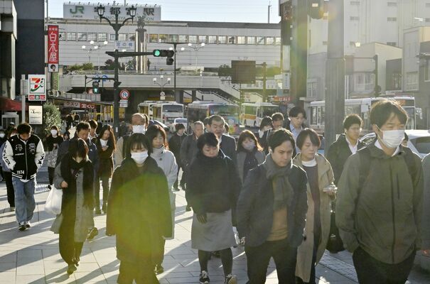 厚着姿で通勤、通学する人たち＝19日午前８時、宇都宮市駅前通り１丁目、河野光吉撮影