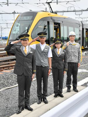 ＬＲＴ車両の前で披露された運転士（左３人）と技術職の制服＝10日午後１時30分、宇都宮市下平出町