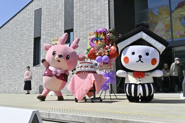 お祝いに駆けつけた「イワシカ」（左）と記念撮影する「とち介」（右）