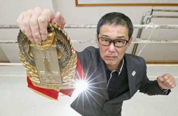 　「モスクワオリンピック候補」と刻まれたベルトを掲げる木庭浩一さん＝２０２０年、熊本市