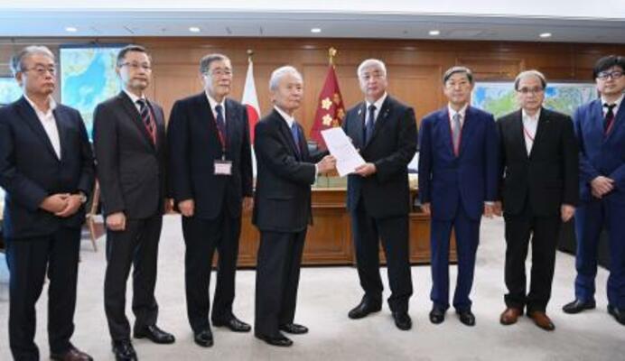 　防衛力の抜本的強化に関する有識者会議を終え、中谷防衛相（右から４人目）に報告書を手渡す、座長の榊原定征元経団連会長＝１９日午後、防衛省（代表撮影）