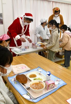サンタ姿で配膳を行う中村市長（奥左）と自身の考案メニュー