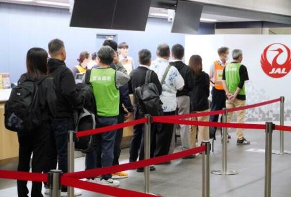 避難計画手順確認のため、保安検査場の前で列を作る避難者役=18日夜、沖縄県宮古島市