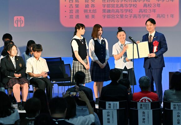 小倉担当相（右）に宣言文を手渡す中高生たち＝24日午後２時５分、宇都宮市宮みらい