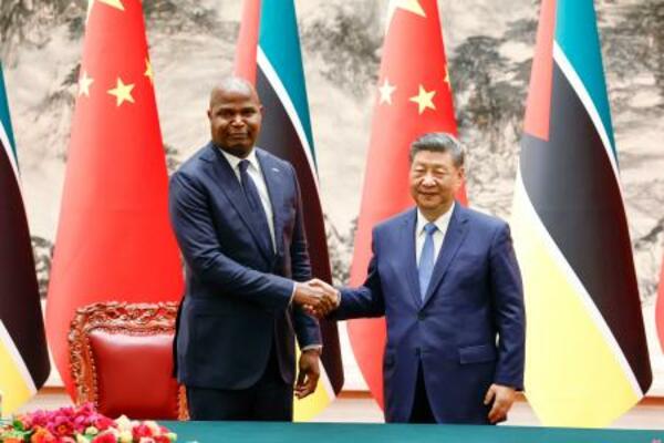 　調印式で握手する中国の習近平国家主席（右）とモザンビークのチャポ大統領＝２１日、北京の人民大会堂（共同）