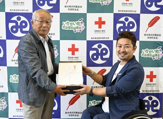 町社協の高久会長（左）に反射材を手渡す大塚さん
