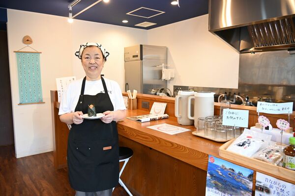 おにぎりモチーフの小物が飾られた店内に立つ店長の日下部さん