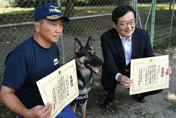 感謝状を贈られたジャスミンと所有者の金井さん（右）、訓練士の池上さん（左）
