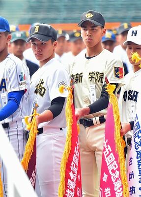 選手宣誓で選抜旗を持って前方に集まる石橋の横松主将（左）、作新の草野主将＝甲子園