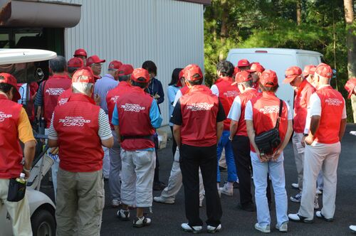 早朝のミーティングで大会関係者の指示を受けるボランティア