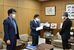 増山副市長（右）に署名を提出する毛塚さん（中央）