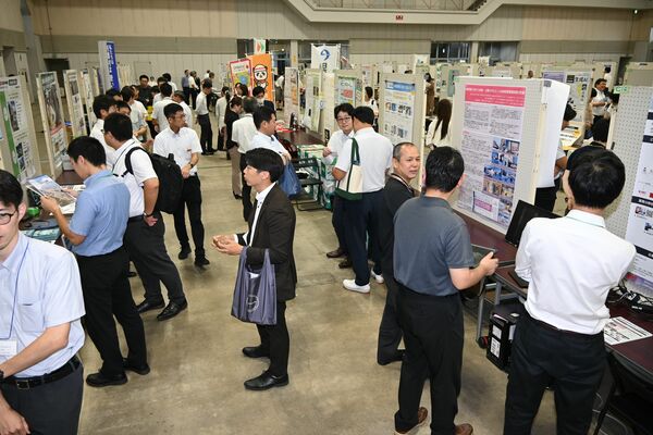 大学や企業・団体、自治体の展示コーナーを巡る来場者＝18日午後、宇都宮市