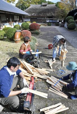 旧濱田邸前でまき割りする参加者