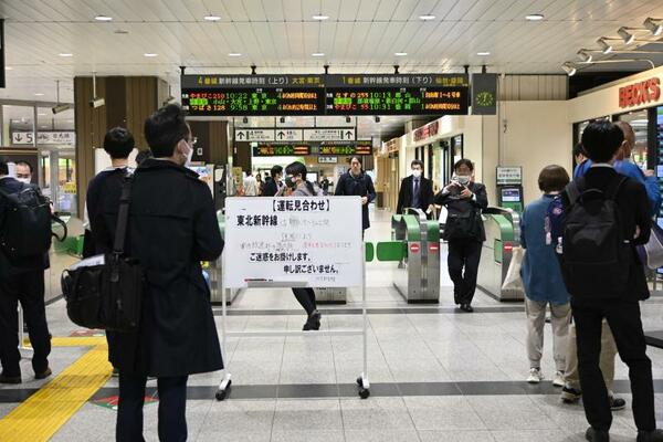 運転見合わせを知らせるホワイトボードが置かれた東北新幹線の改札前＝２６日午後０時１０分、ＪＲ宇都宮駅