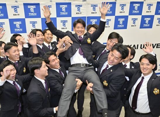 日本ハムから３位指名を受け、チームメートに胴上げされる東海大の大塚内野手（中央）＝23日午後６時35分、神奈川県平塚市の同大湘南キャンパス、広瀬華撮影