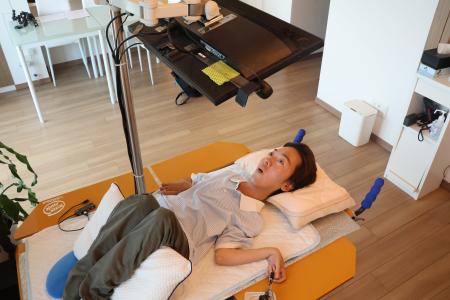 　視線入力装置を備えたパソコンを使って仕事をする佐藤仙務さん＝７月