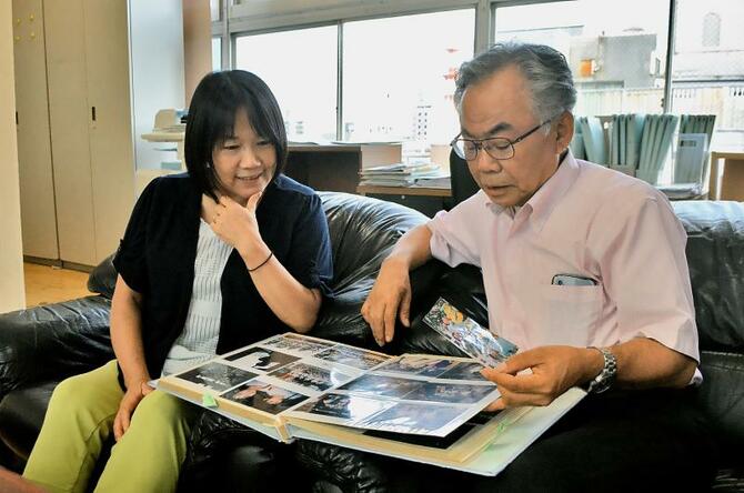 早矢香さんの幼い頃の写真を眺めながら当時を振り返る司さん(右)と美恵さん