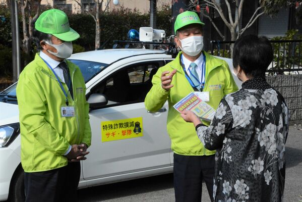 戸別訪問で特殊詐欺被害防止を呼びかける岸田隊長（中央）＝１８日午前10時45分、宇都宮市駒生町