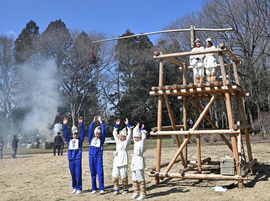 のろし（後方）を上げ、見晴台の前で万歳する生徒たち