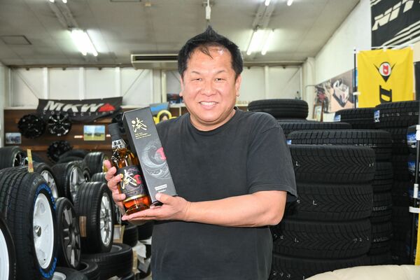 ライスウイスキー「湊 SOU」を手にする塚田社長=真岡市