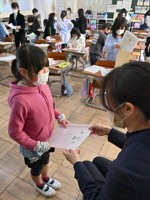 担任から通知表を受け取る児童＝２３日午前１０時、那須烏山市愛宕台