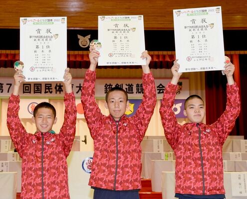 銃剣道少年男子で初優勝を飾り、賞状を掲げて喜ぶ栃木県チームの（左から）大森、真鍋、斎藤＝９日午後４時40分、壬生高体育館