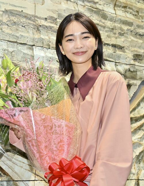 花束を手にした見上さん=22日午後4時、宇都宮市昭和1丁目