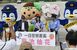 一日警察署長を委嘱され、来場者の記念撮影に応じる菊池さん（中央）