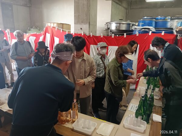 無料試飲コーナーで日本酒などをカップで受け取る来場者＝４月１１日、那須烏山市