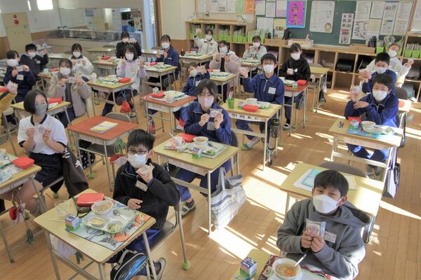 イチゴのタルトを掲げる児童たち