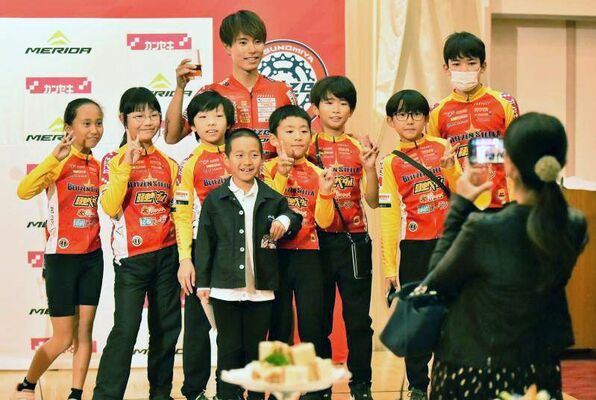 ブリッツェンの花田（中央奥）と写真に収まる子どもたち＝宇都宮市